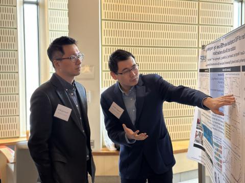 Two men discuss a poster presentation.